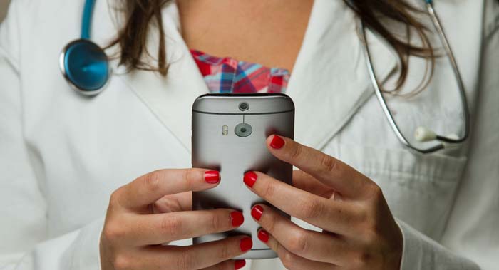 Ärztin nutzt Online-Terminkalender über ihr Smartphone